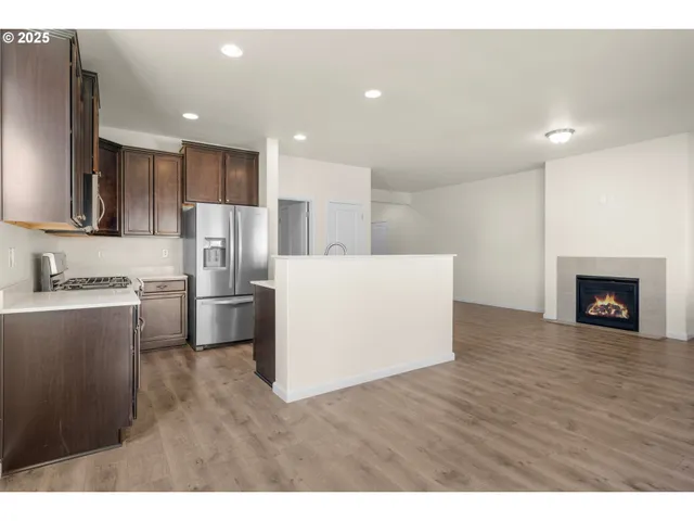 a living room with a refrigerator and a stove top oven