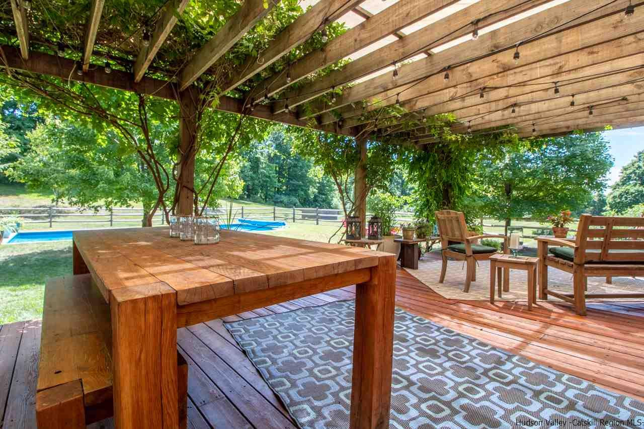173 Peak Road Stone Ridge, NY 12484 - Photo 18 of 34 a view of a patio with table and chairs a barbeque with wooden floor and fence