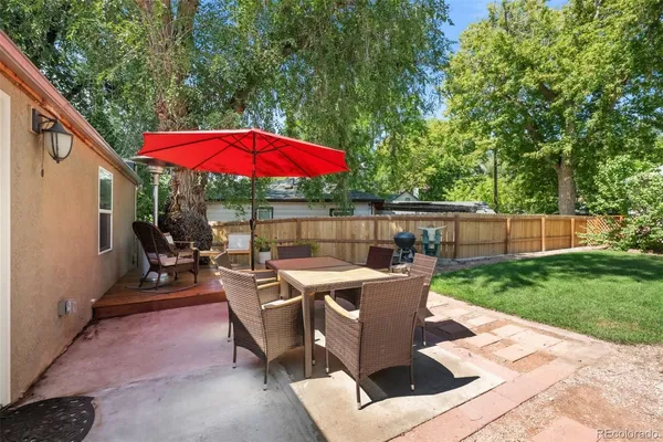 a view of a patio with table and chairs under an umbrella
