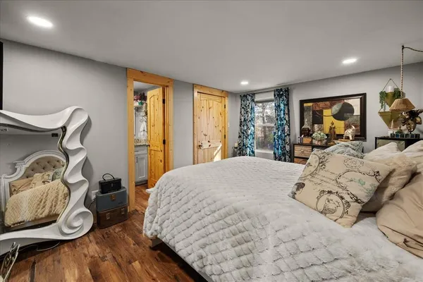 a bedroom with a bed and a flat tv screen on dresser