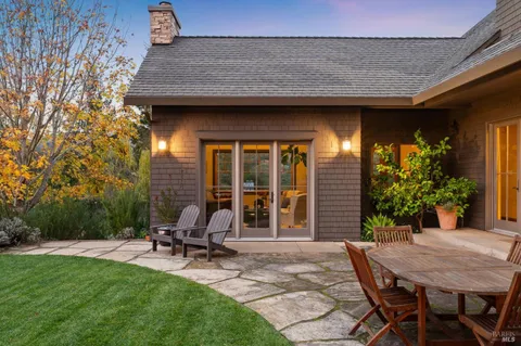 a view of a house with backyard sitting area and garden