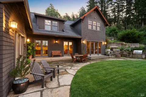 a view of a house with backyard sitting area and garden