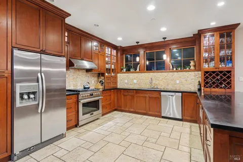 a kitchen with stainless steel appliances granite countertop a refrigerator and a stove