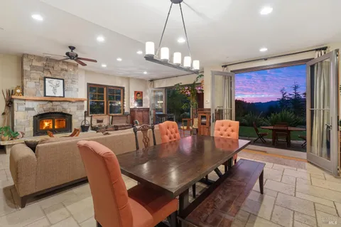 a dining room with furniture a fireplace and large window
