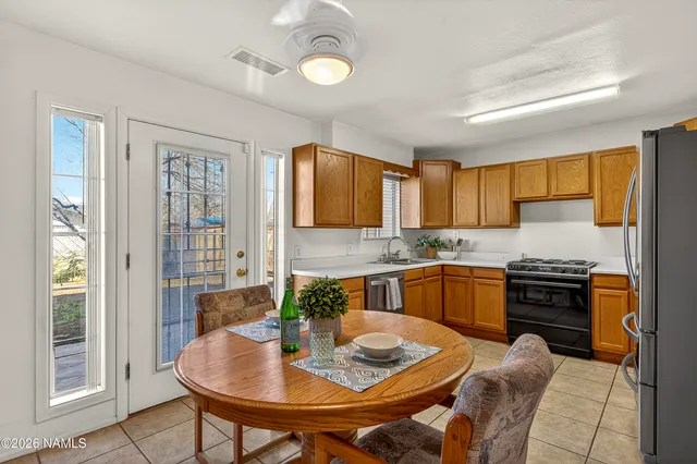 a kitchen with stainless steel appliances granite countertop a stove a sink dishwasher and a refrigerator with wooden floor