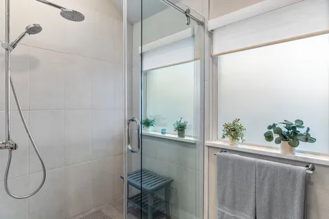 a bathroom with a glass shower door and mirror