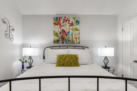 a bedroom with a bed and painting on the wall
