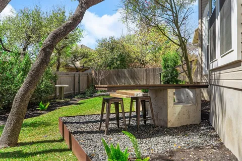 a front view of a house with patio and a garden