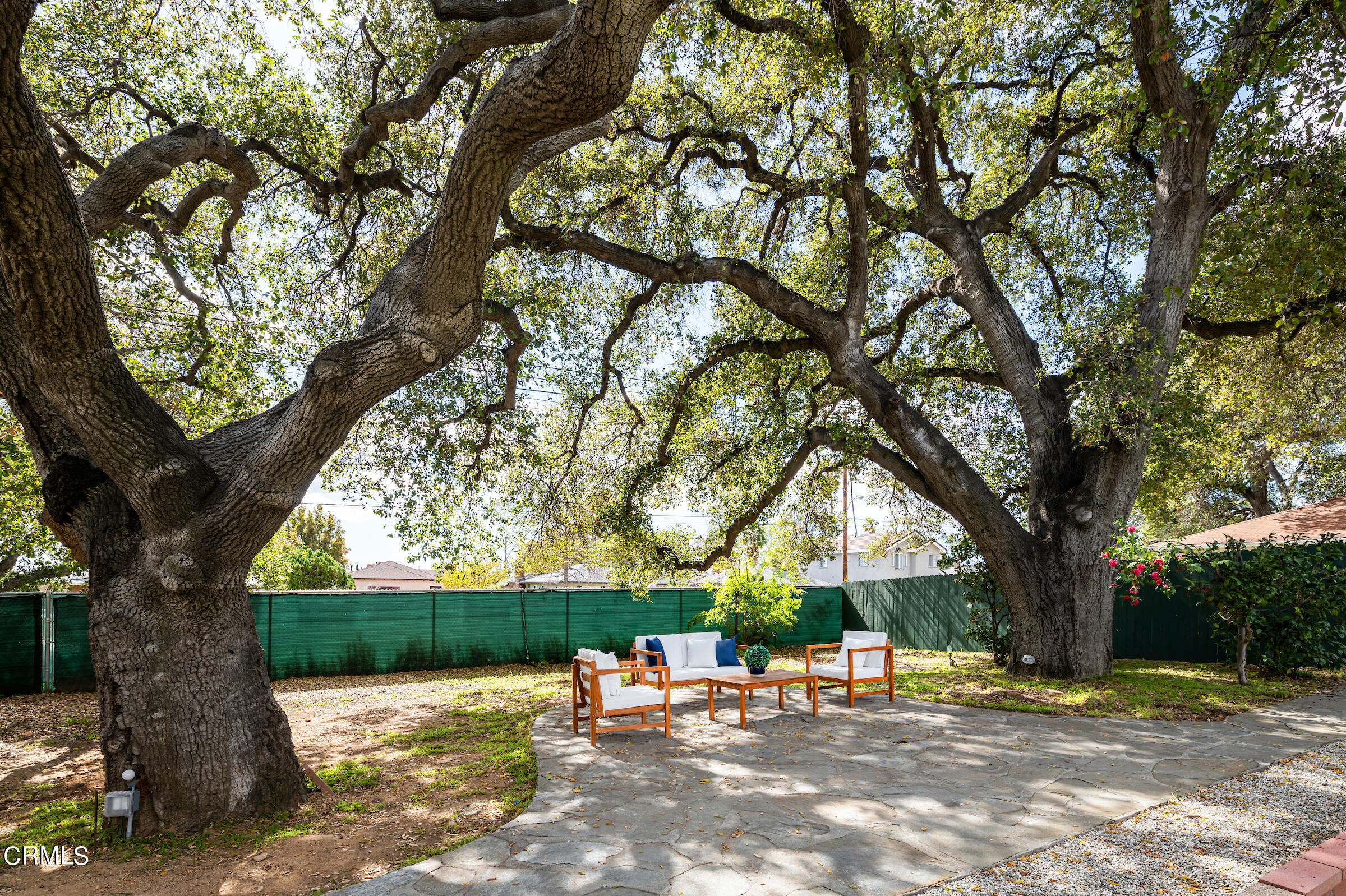 1673 Coolidge Avenue Altadena, CA 91001 - Photo 36 of 59 a view of a backyard with a table and chairs under a large tree