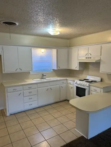 a kitchen with granite countertop white cabinets and white appliances