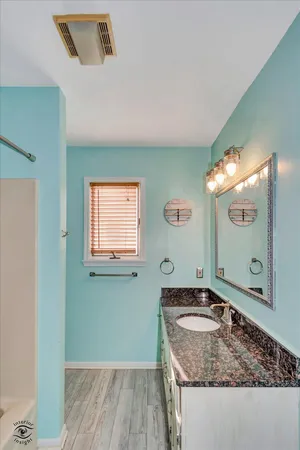 a bathroom with a granite countertop sink a mirror and window