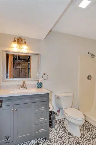 a bathroom with a toilet a sink and mirror