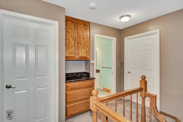 a view of a hallway to room with wooden floor and staircase