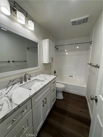 a bathroom with a granite countertop double vanity sink a mirror and a shower