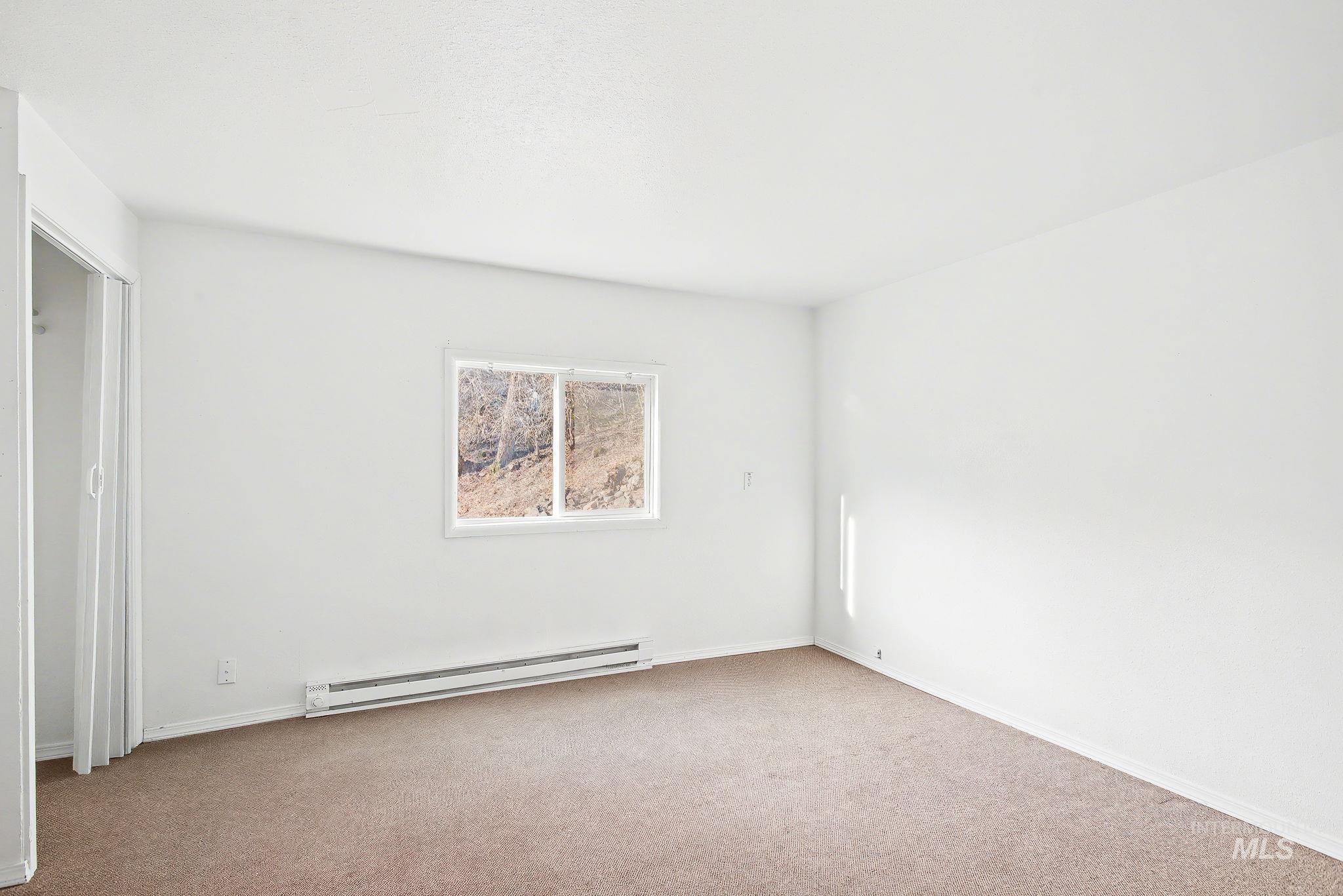 150 Elm Street Orofino, ID 83544 - Photo 21 of 36 Room featuring light beige carpeting, white painted walls, and a window with a white frame