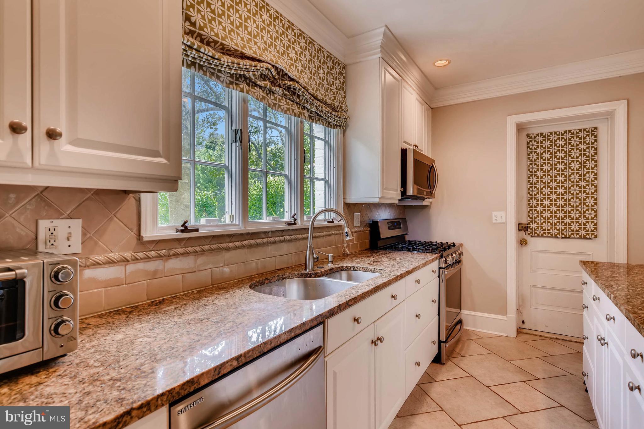 106 Enfield Road Baltimore, MD 21212 - Photo 9 of 27 a kitchen with a sink stove and cabinets