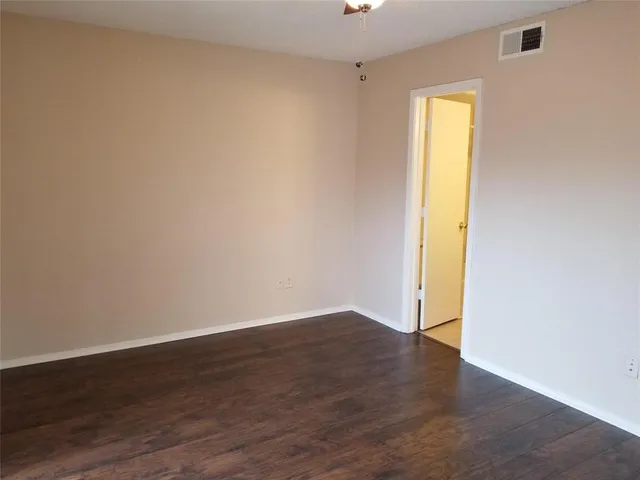 an empty room with wooden floor and a window