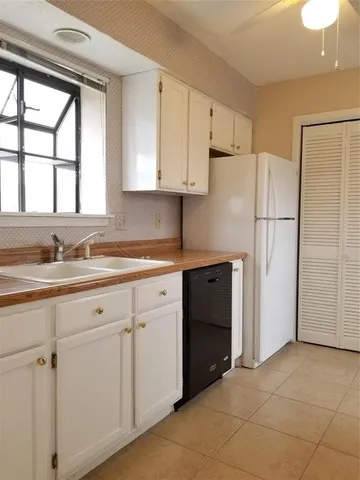a kitchen with granite countertop white cabinets and refrigerator