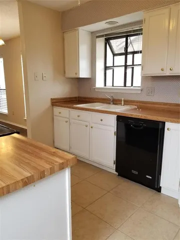 a kitchen with granite countertop a stove sink and cabinets