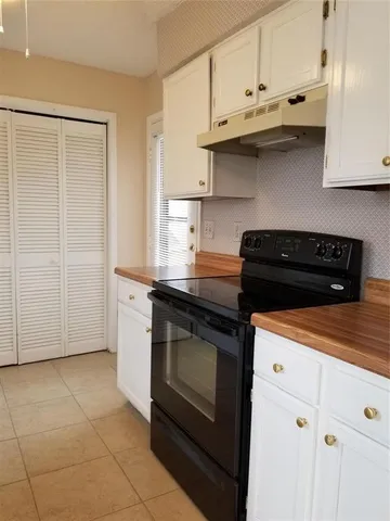 a kitchen with stainless steel appliances granite countertop a stove and a white cabinets