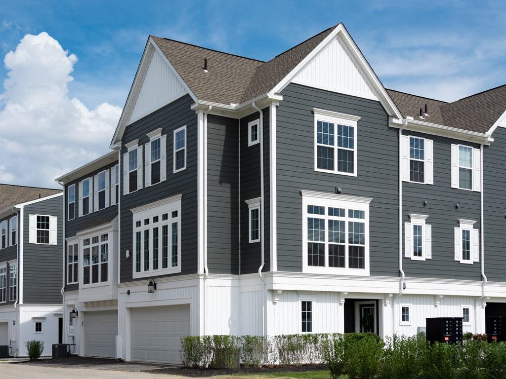 a view of a big house with large windows and a yard