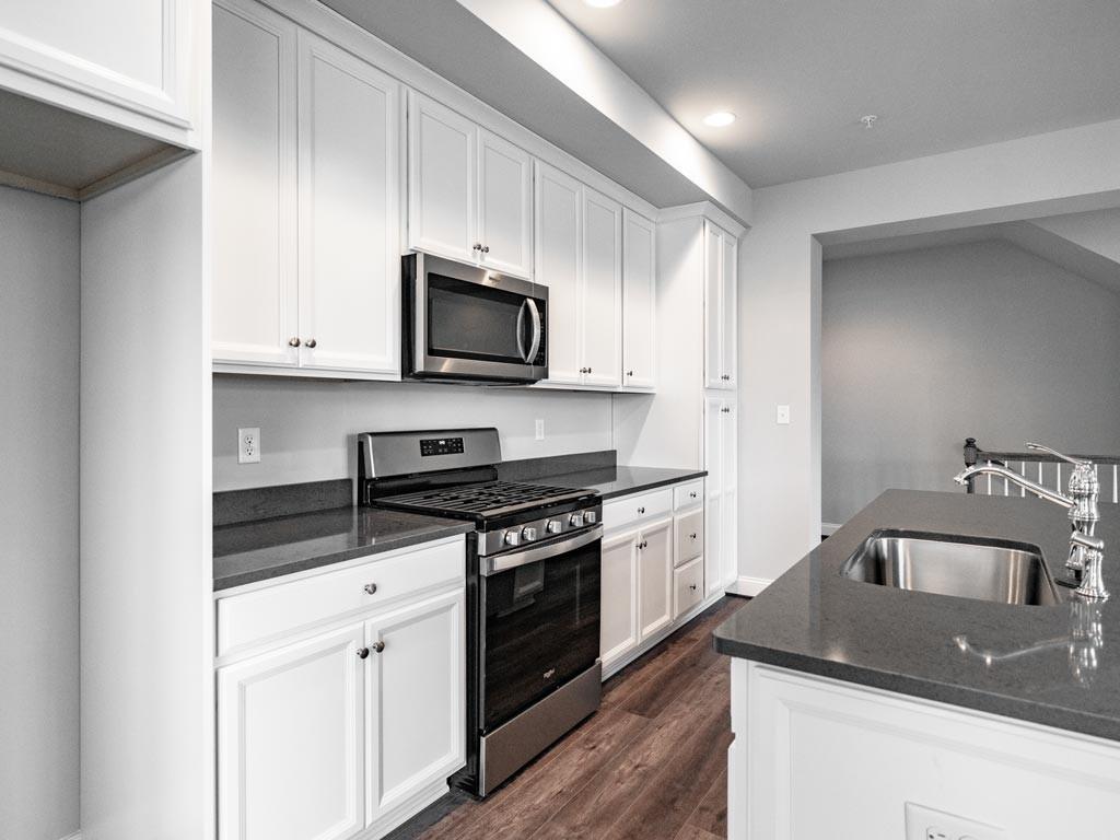 3106 Tulane Way Bridgeville, PA 15017 - Photo 7 of 25 a kitchen with stainless steel appliances granite countertop a sink a stove a microwave and cabinets