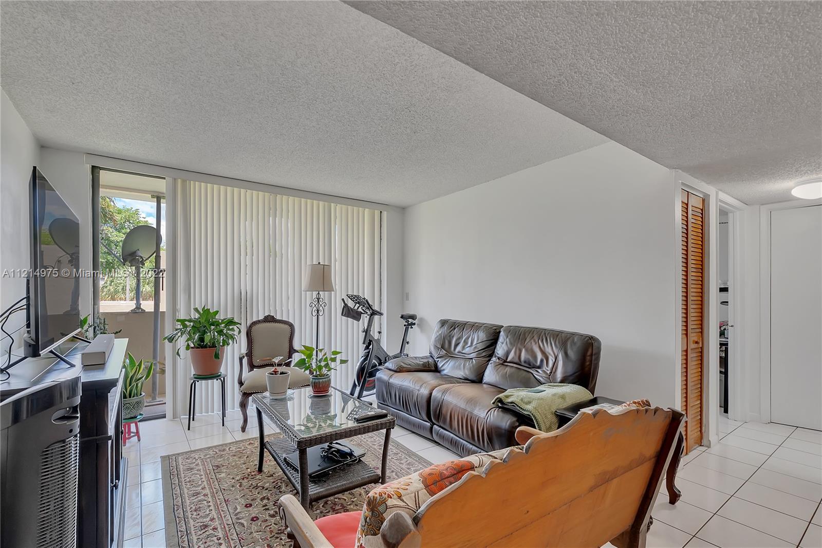 8002 Southwest 149th Avenue, Unit B201 Miami, FL 33193 - Photo 3 of 18 a living room with furniture and a flat screen tv