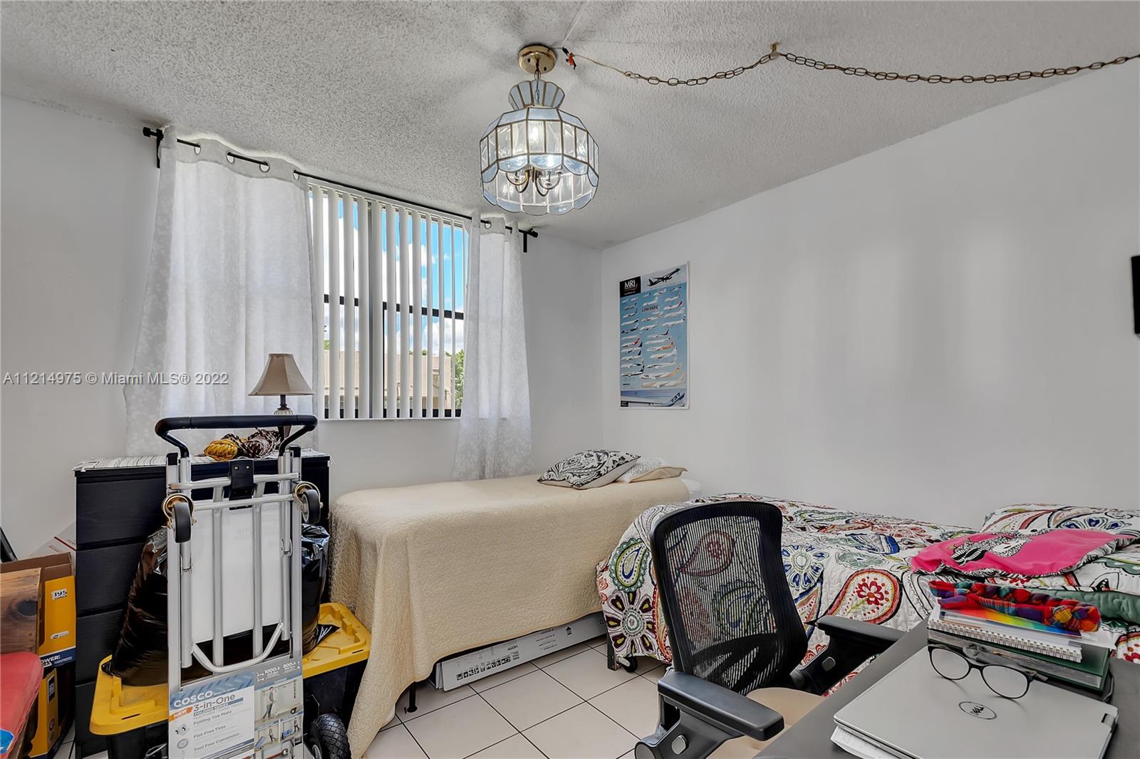 8002 Southwest 149th Avenue, Unit B201 Miami, FL 33193 - Photo 5 of 18 a bedroom with a bed furniture and windows