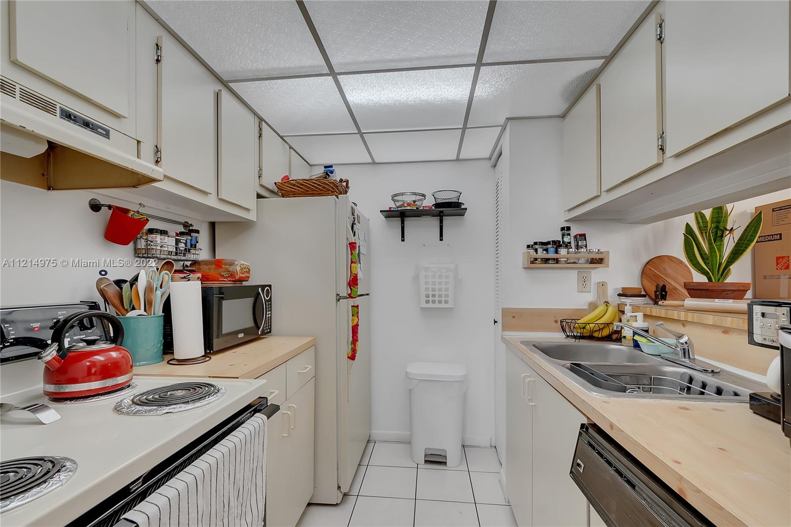 8002 Southwest 149th Avenue, Unit B201 Miami, FL 33193 - Photo 8 of 18 a kitchen with stainless steel appliances granite countertop a sink and stove