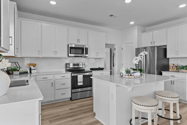 a kitchen with white cabinets and stainless steel appliances