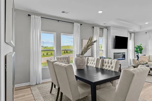 a living room with furniture a flat screen tv and a large window