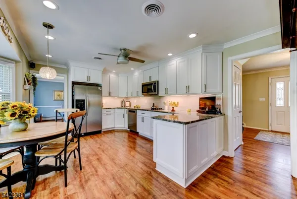 a kitchen with stainless steel appliances kitchen island granite countertop a sink and a refrigerator
