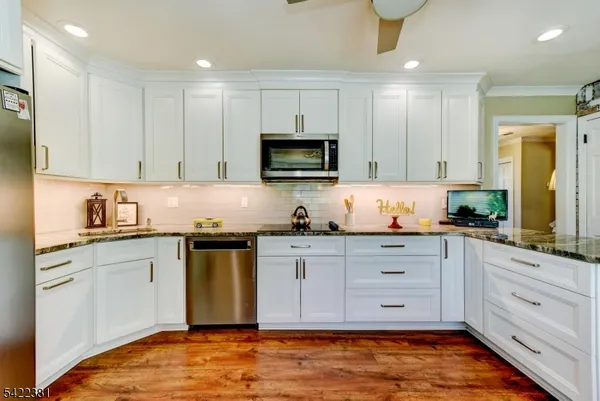 a kitchen with granite countertop cabinets stainless steel appliances and a sink