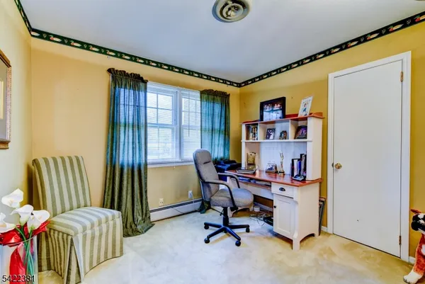 a view of a workspace with furniture and a window