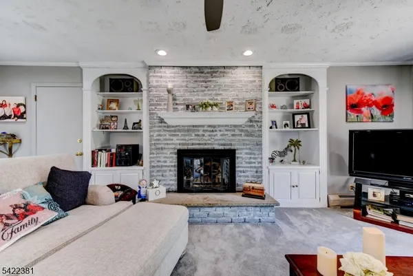 a living room with furniture a flat screen tv and a fireplace