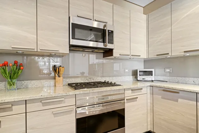 a kitchen with granite countertop stainless steel appliances a stove a sink and a microwave