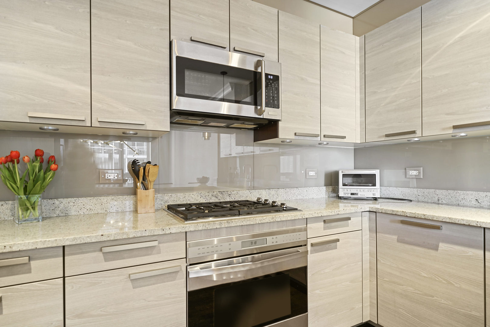 10 East Delaware Place, Unit 18E Chicago, IL 60611 - Photo 12 of 57 a kitchen with granite countertop stainless steel appliances a stove a sink and a microwave