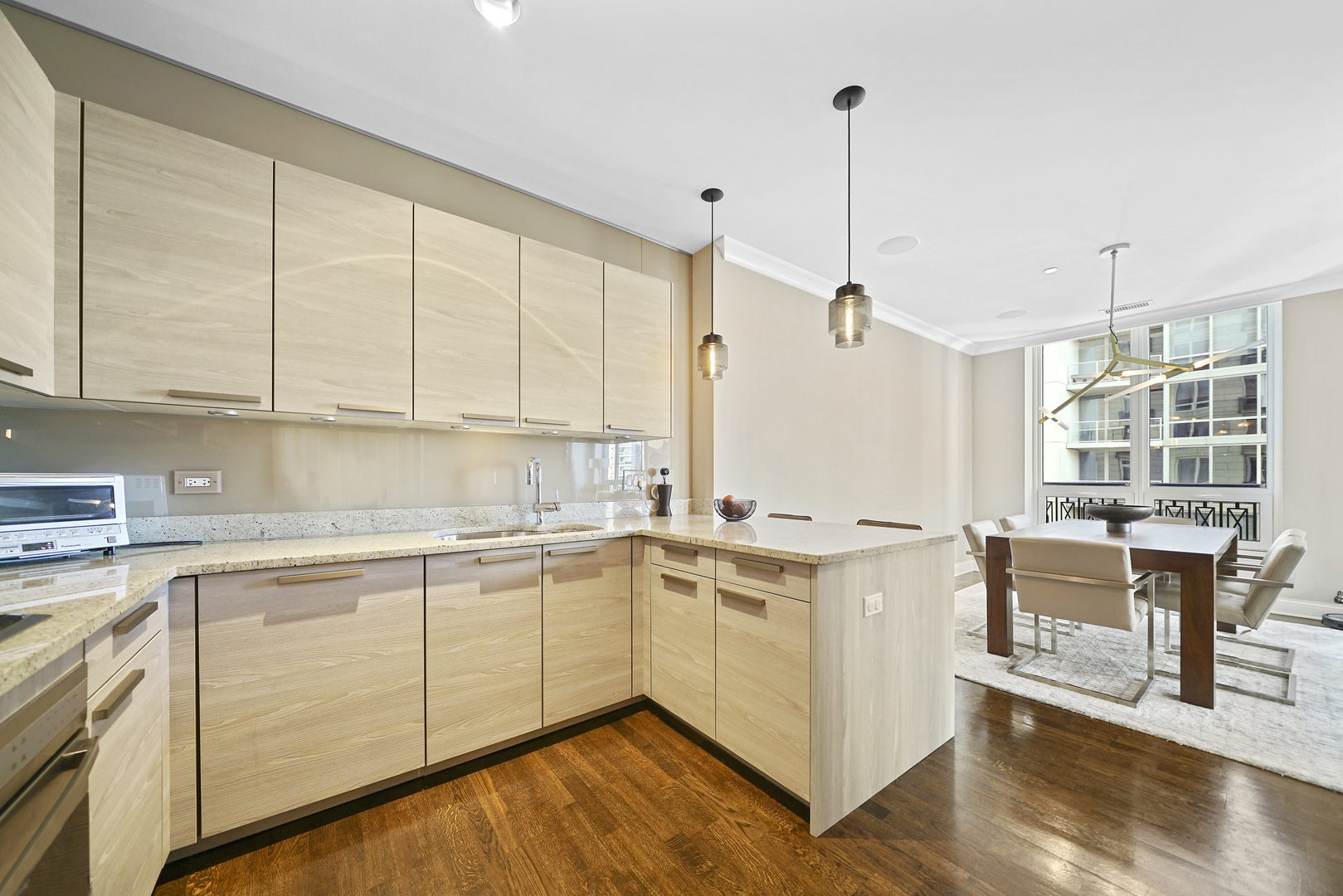10 East Delaware Place, Unit 18E Chicago, IL 60611 - Photo 10 of 57 a kitchen with a stove a sink and white cabinets with wooden floors