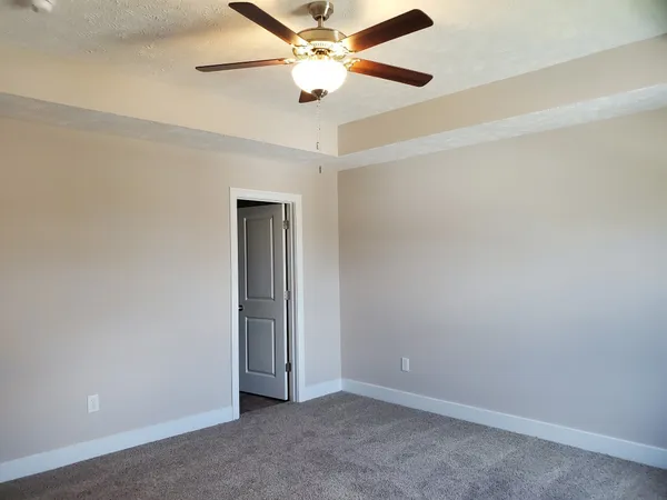 an empty room with window and ceiling fan