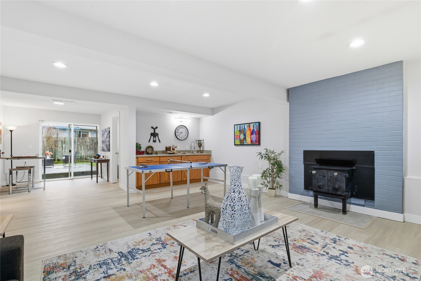 4426 Northeast 17th Street Renton, WA 98059 - Photo 26 of 36 a living room with furniture a fireplace and a dining table with wooden floor