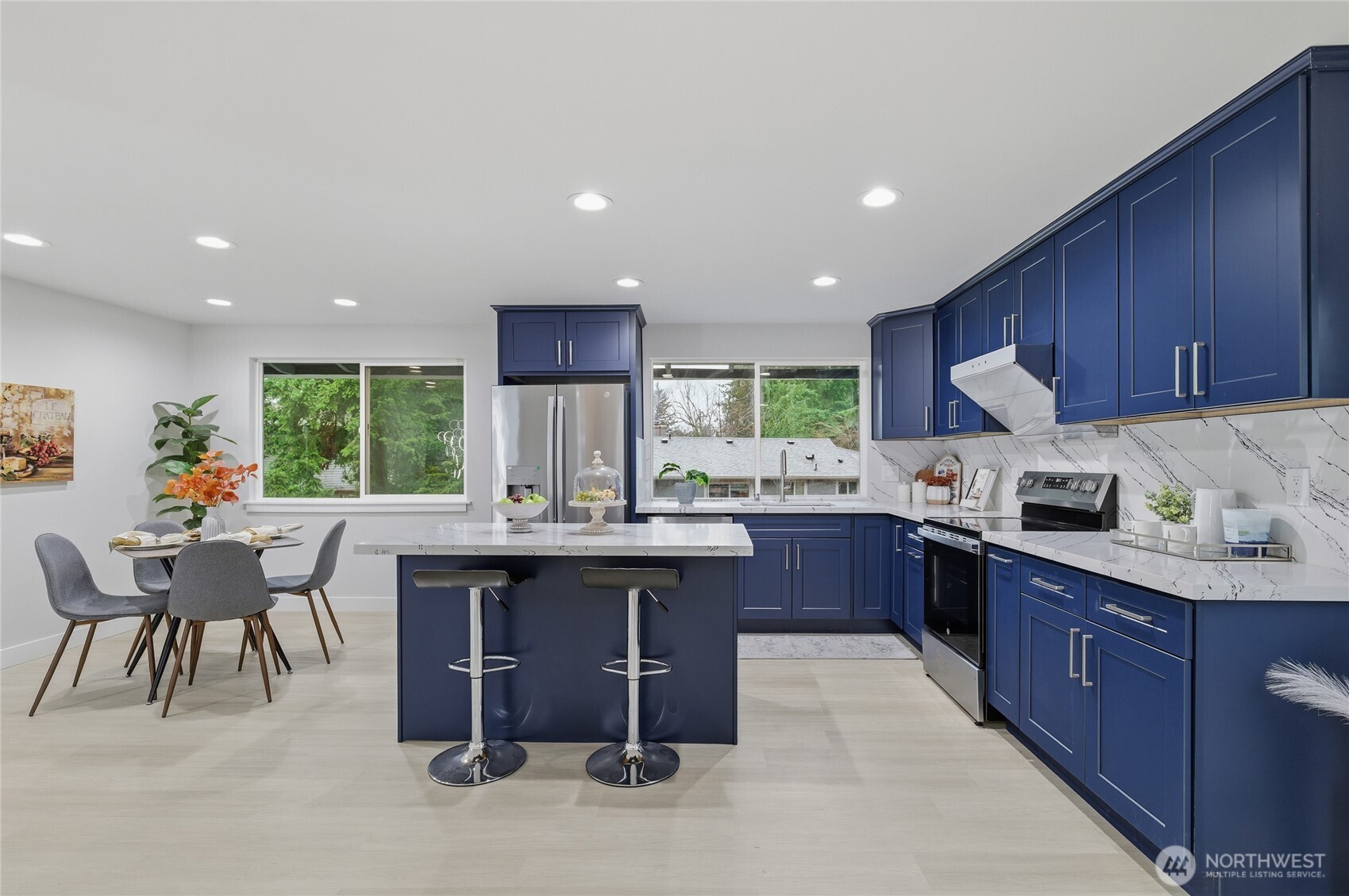 4426 Northeast 17th Street Renton, WA 98059 - Photo 8 of 36 a kitchen with stainless steel appliances granite countertop a table chairs sink refrigerator and cabinets