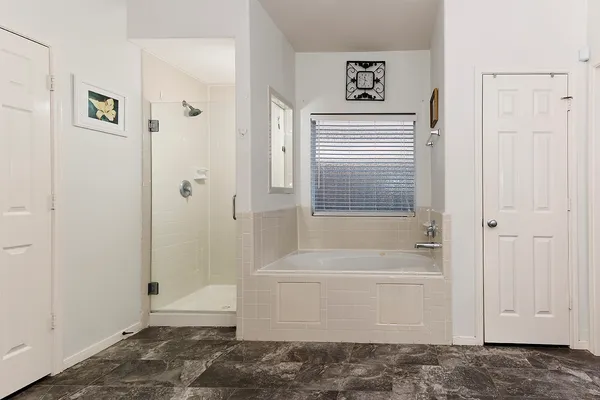 a view of an empty room with wooden floor and a ceiling fan