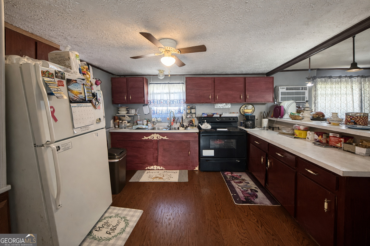 459 Louie Hightower Road Collins, GA 30421 - Photo 5 of 22 a kitchen with kitchen island wooden floors stainless steel appliances a sink a counter top space and a window