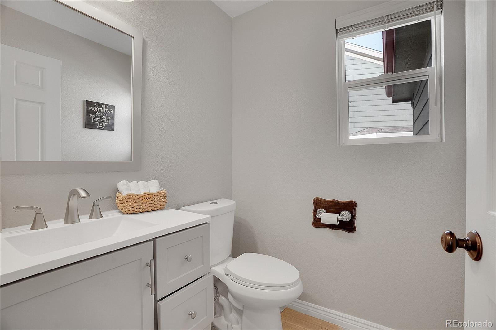 6348 Westview Circle Parker, CO 80134 - Photo 13 of 27 a bathroom with a toilet sink vanity and mirror