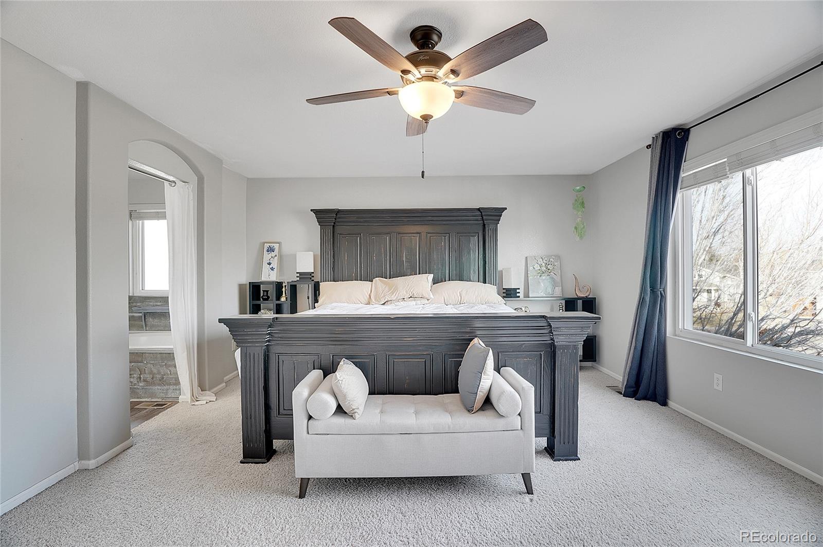 6348 Westview Circle Parker, CO 80134 - Photo 21 of 27 a bedroom with a large bed a chandelier and window