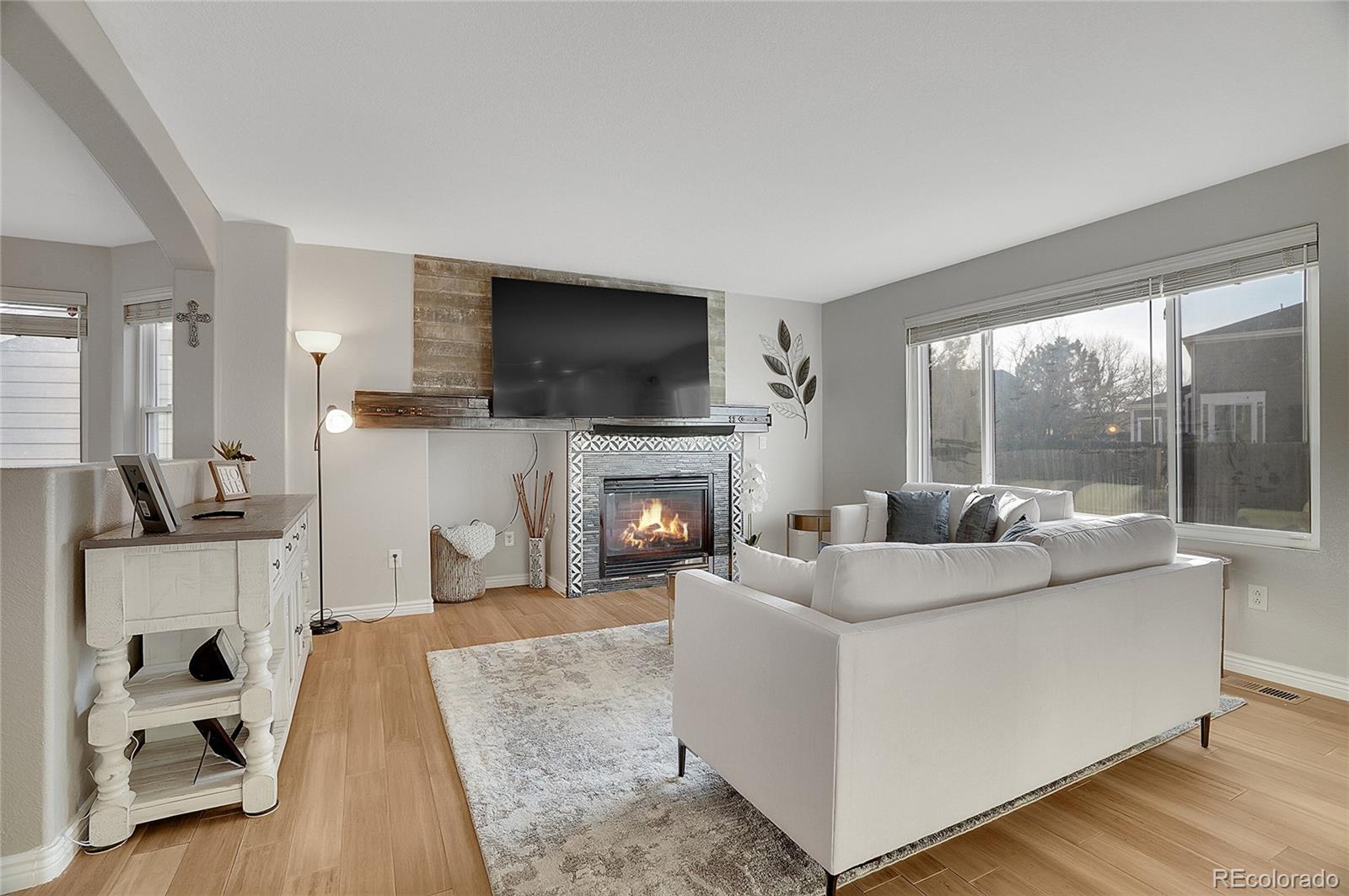 6348 Westview Circle Parker, CO 80134 - Photo 7 of 27 a living room with furniture a flat screen tv and a fireplace