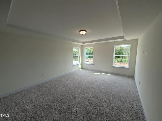 an empty room with windows and closet area