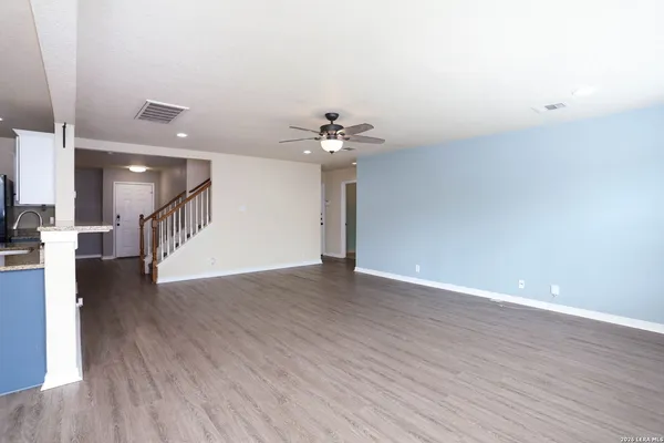 a view of an empty room with wooden floor