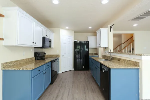a kitchen with stainless steel appliances granite countertop a stove a sink and a refrigerator