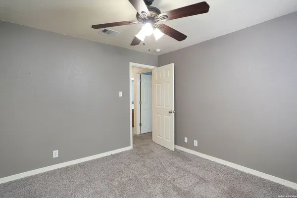 an empty room and chandelier fan